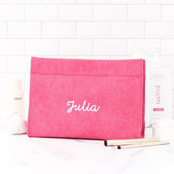 hot pink terry toiletry bag on bathroom counter