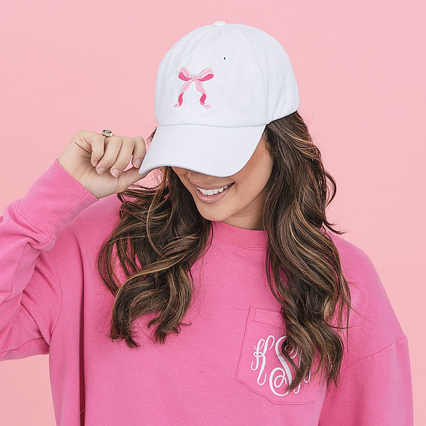 girl wearing white pink bow baseball hat