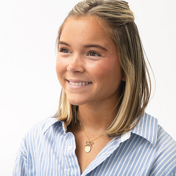 girl wearing gold bow necklace