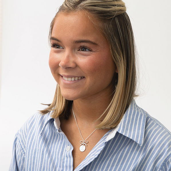 girl wearing silver bow necklace