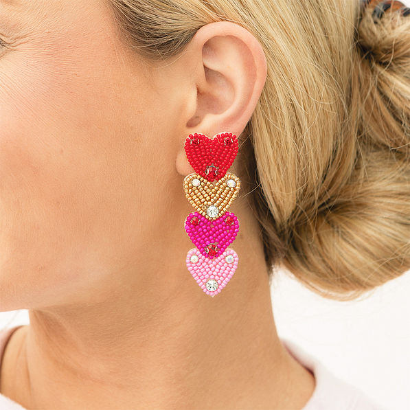 pink layered heart earrings in ear