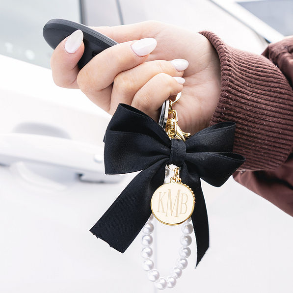black monogrammed bag charm keychain on car keys