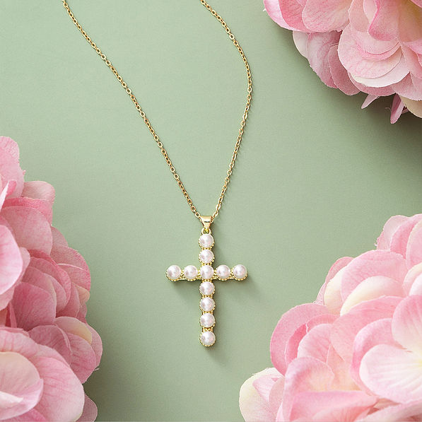 pearl cross necklace on green with flowers