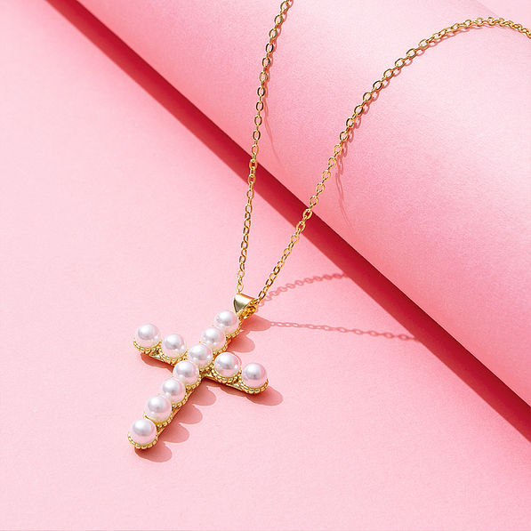 pearl cross necklace on pink