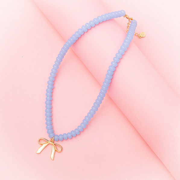 Beaded bow necklace on pink