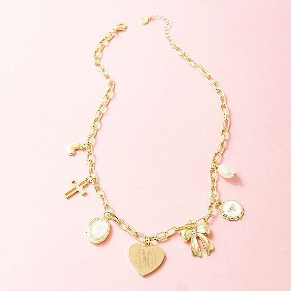 gold charm necklace on pink background