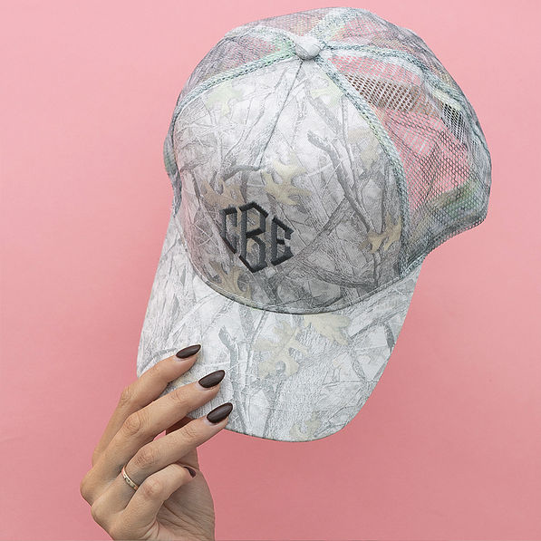 girl holding up hat on pink