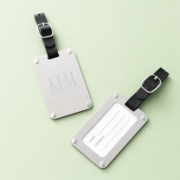 silver stainless steel luggage tag on green background