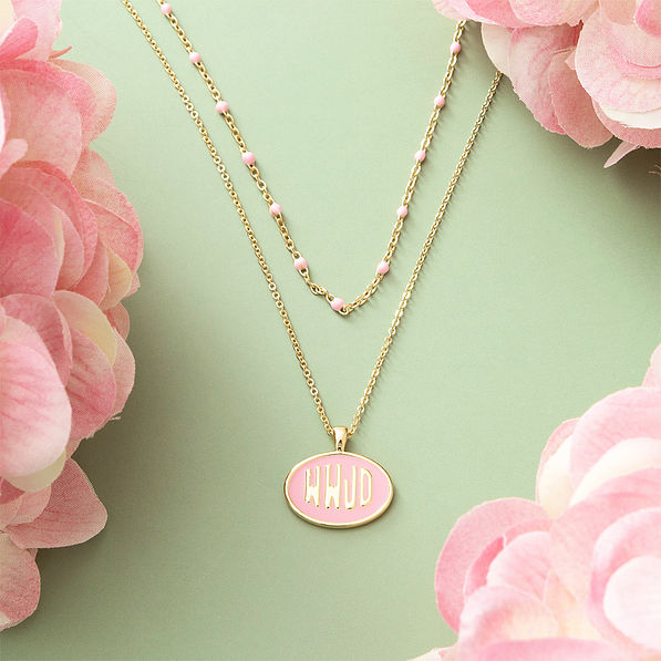 pink wwjd necklace on green background