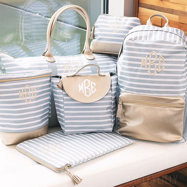 monogrammed gray striped travel bags on bench