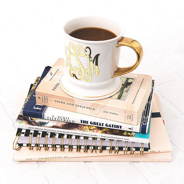 monogrammed coffee mug on stack of books