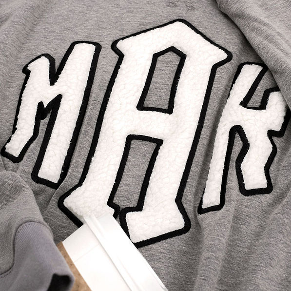 close up of sherpa letters on letterman sweatshirt