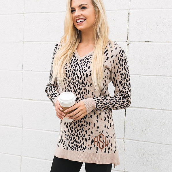 monogrammed leopard sweater tunic in front of white wall