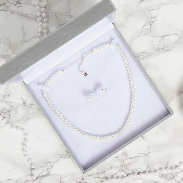 open box with set of pearl earrings and necklace on marble background