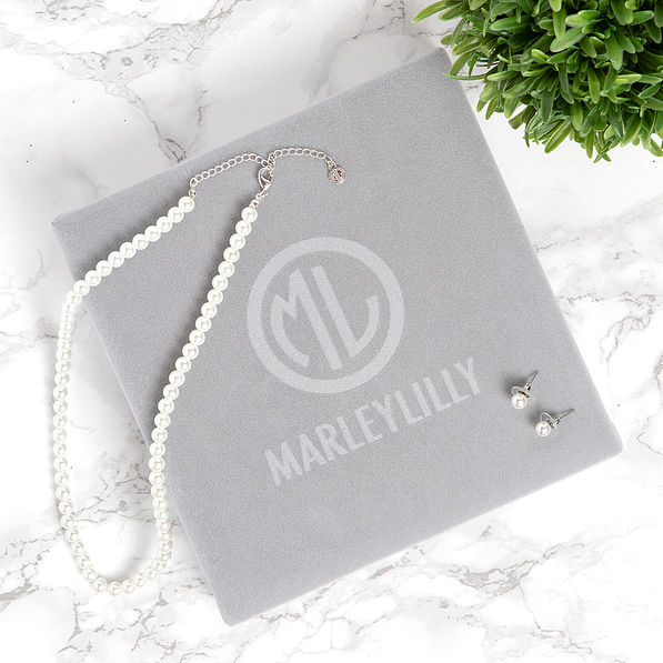 closed box with pearl earrings and necklace set on marble