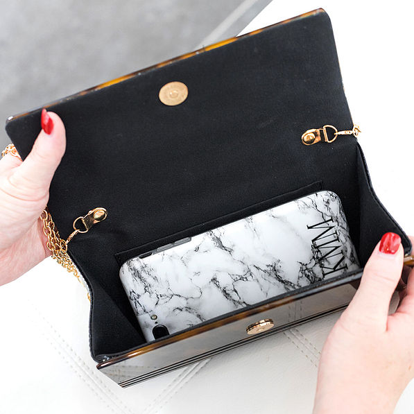 cell phone inside of monogrammed tortoise clutch