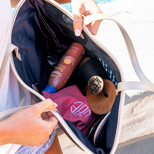 inside pineapple beach tote with monogrammed sandals and hat and sunscreen