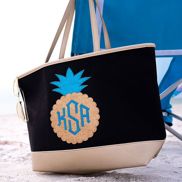 sparkly pineapple beach tote with monogram hanging on beach chair
