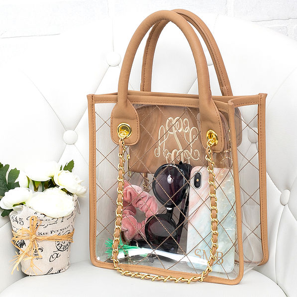 monogrammed clear handbag sitting on white chair with flowers