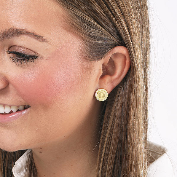gold monogrammed disc earrings on brunette