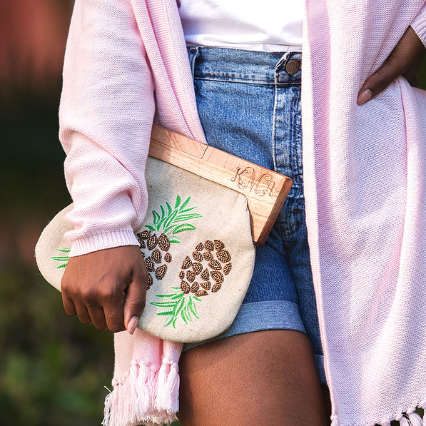 close up of monogrammed pineapple clutch with monogrammed fringe cardigan