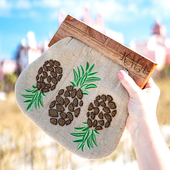 personalized pineapple clutch with hotel in background