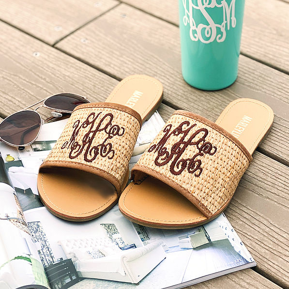 monogrammed straw slide sandals with magazine and sunglasses on dock