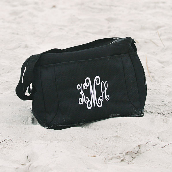 monogrammed black can cooler sitting in sand at beach