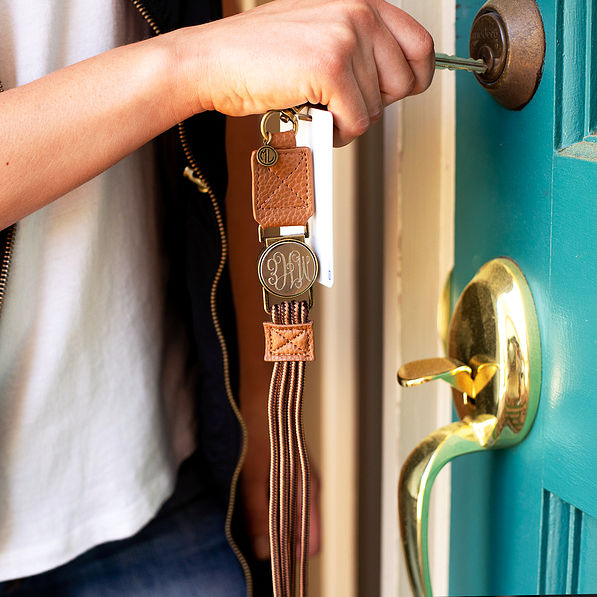brown leather and lace lanyard with key opening a door