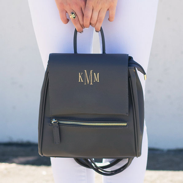 girl holding monogrammed mini backpack by handle