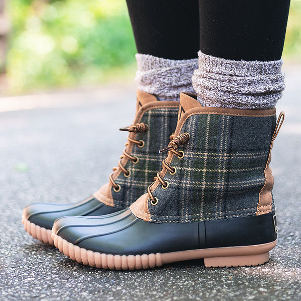 side view of monogrammed plaid duck boots on asphalt