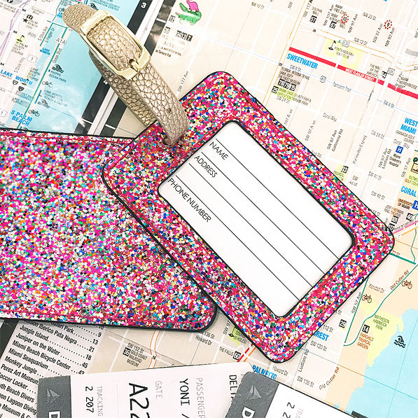 confetti glitter luggage tag front and back laying on a map