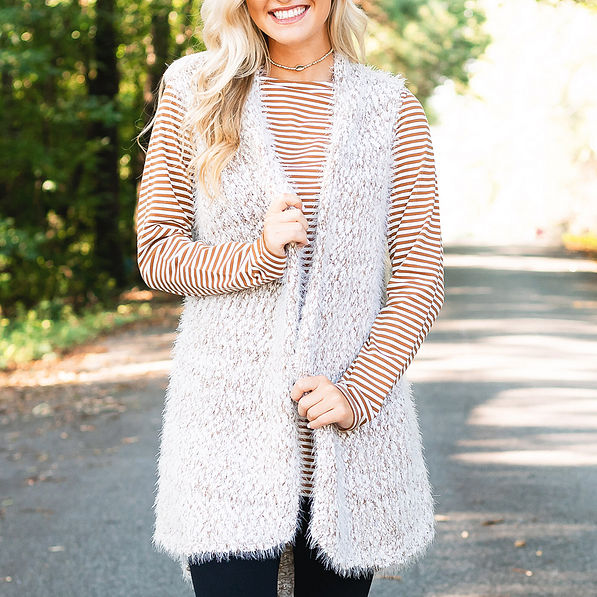 tan striped two way tunic with scoop neck in front layered with cozy knit vest