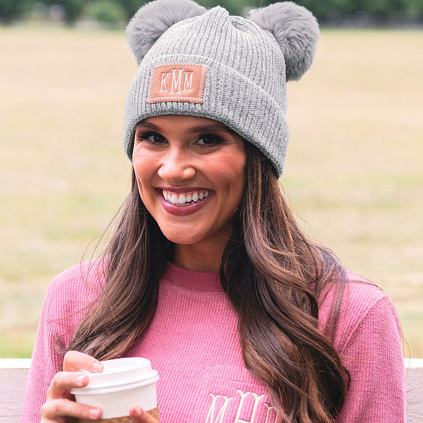 grey monogrammed pom pom beanie on brunette