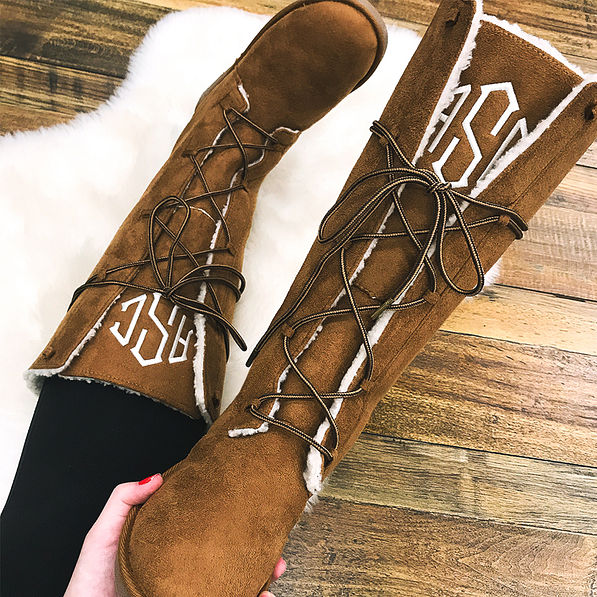 holding monogrammed lace up sherpa boots