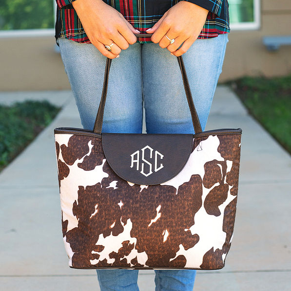 woman holding monogrammed cowhide tote in hands