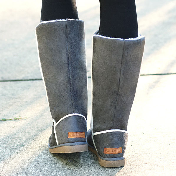 back of grey tall suede sherpa boots with leather branding