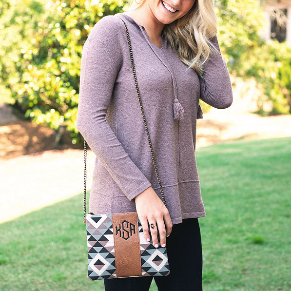 monogrammed aztec crossbody clutch on shoulder