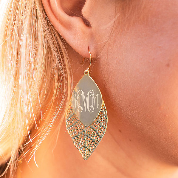 gold fall leaf earrings in ear