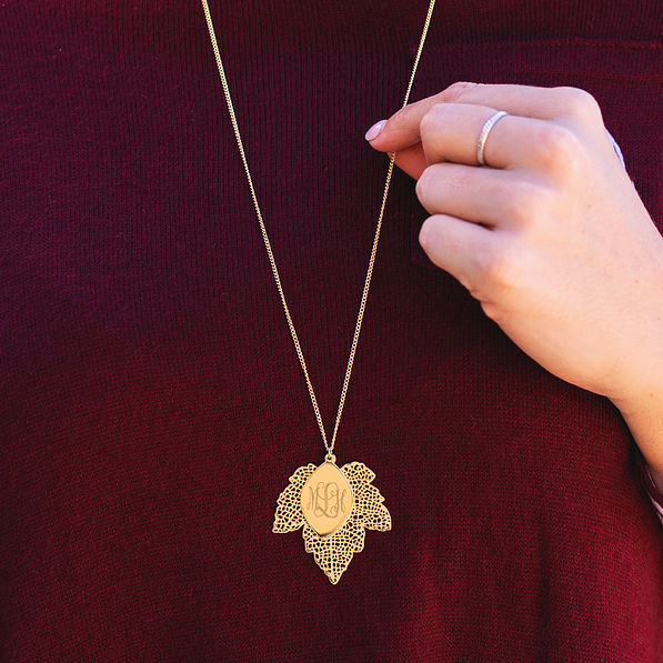 long monogrammed gold leaf necklace with burgundy sweater