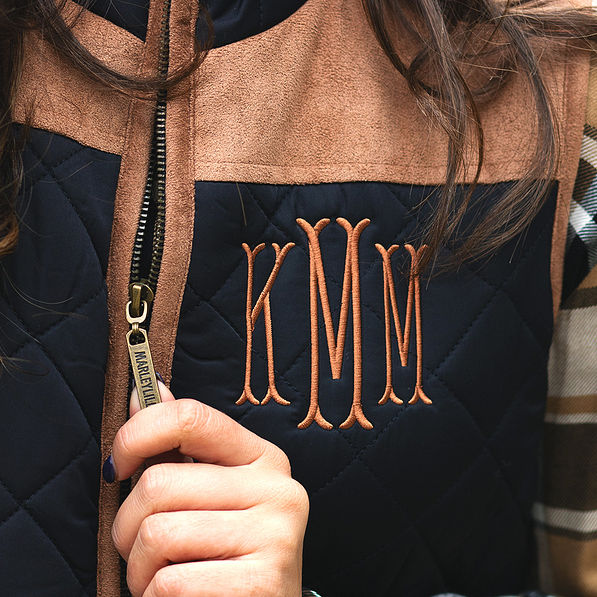 close up of quilted barn vest and branded zipper pull