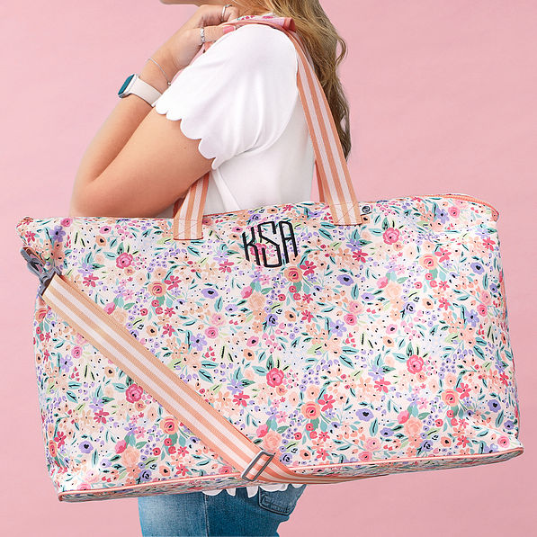 coral floral weekend bag on shoulder pink background
