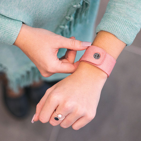 blush faux leather slap bracelet on wrist with mint cardigan