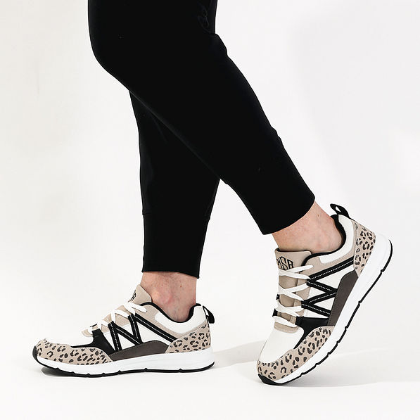 side view with leggings of monogrammed brown leopard sneakers