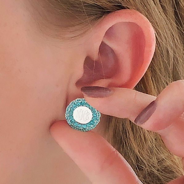 blue and silver monogrammed stud earrings in ear