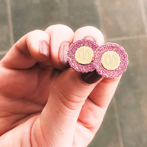 girl holding monogrammed pink and gold cluster earrings