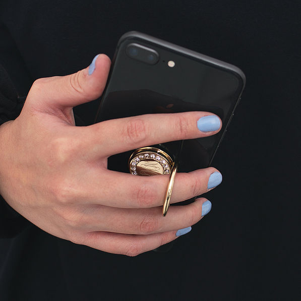 hand holding iphone with gold monogrammed rhinestone phone ring