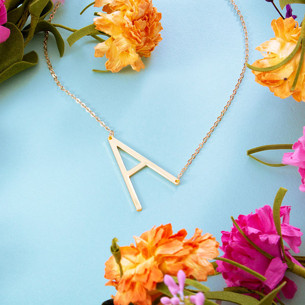 gold sideways single initial necklace with flowers