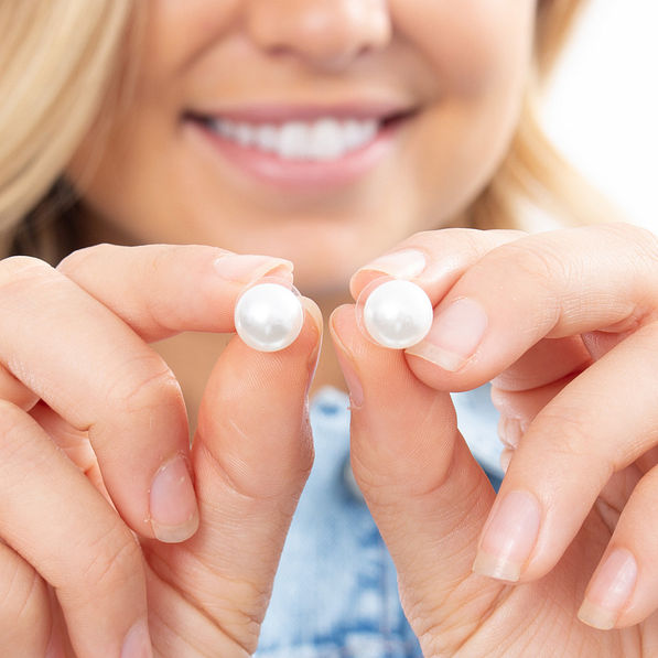 girl holding classy pearl stud earrings