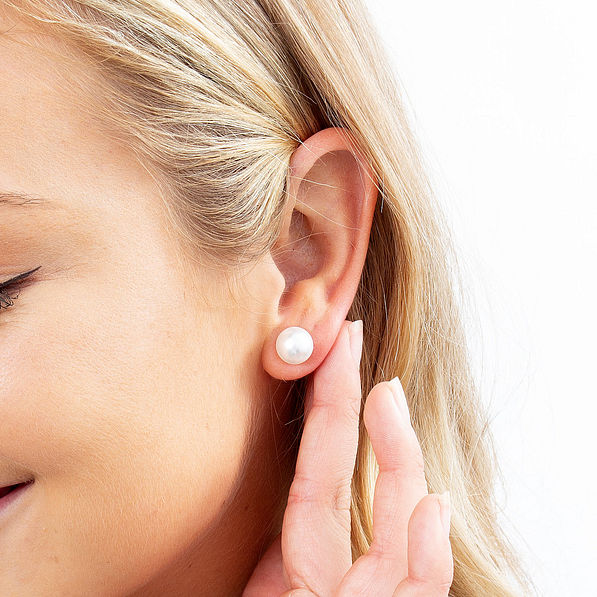 model wearing pearl stud earrings